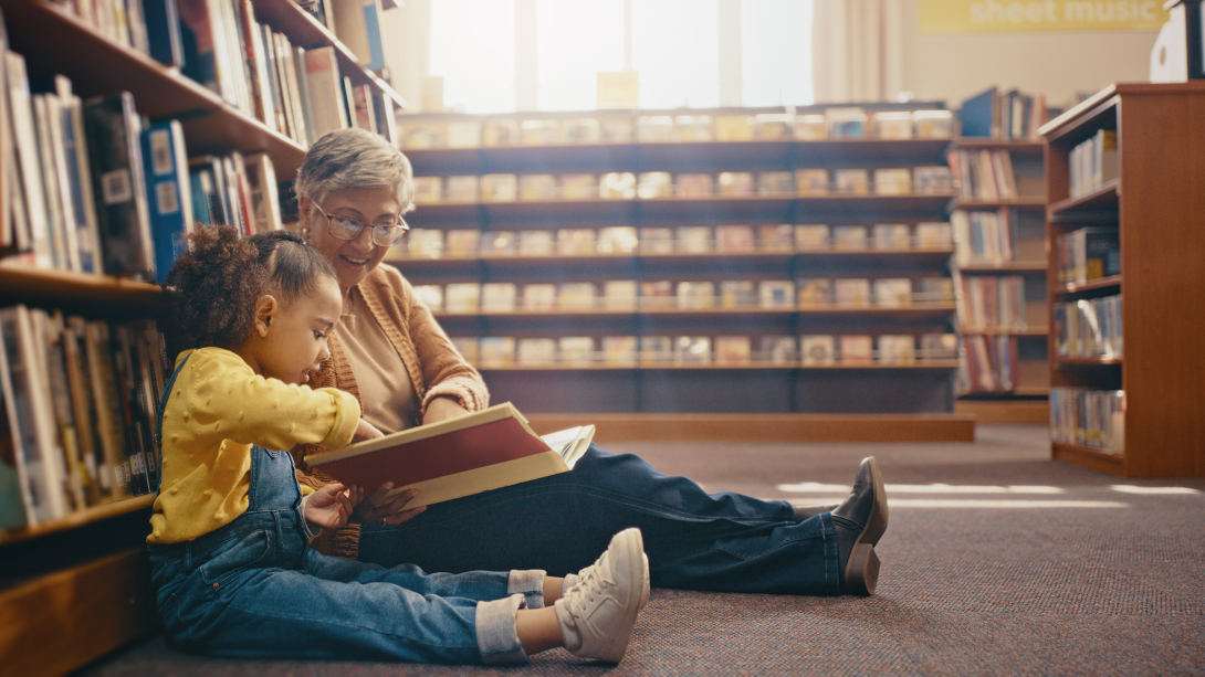 woman reading book to child in library